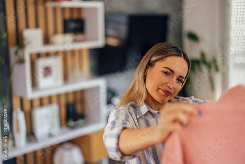 Photos Delighted caucasian woman, thinking about packing that one sweater