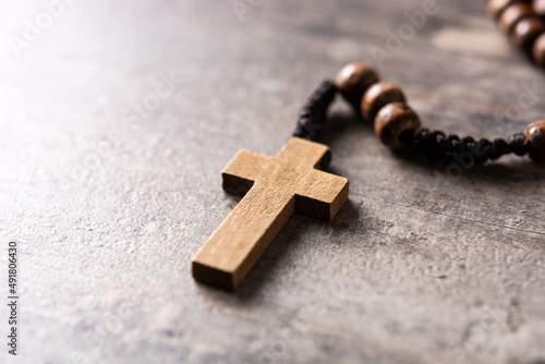 Rosary catholic cross on wooden table. Copy space