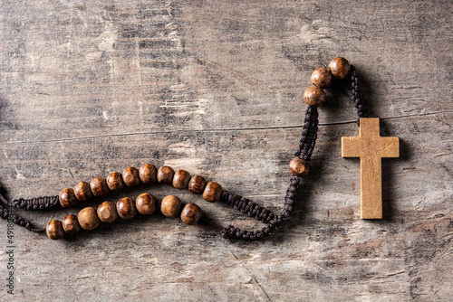 Rosary catholic cross on wooden table photo