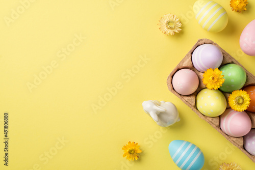 Canvas Print Top view of a half carton with multicolored Easter eggs and flowers white figure