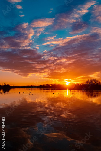 Beautiful sunset with swans, ducks and reflections near Plattling, Isar, Bavaria, Germany