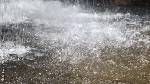 Waterfall water falling and hitting the water surface in the forest photo