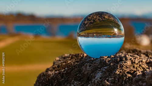 Crystal ball alpine landscape shot on a rock near the famous Waginger See lake, Waging am See, Bavaria, Germany