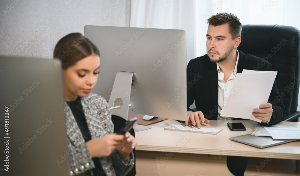Young attractive woman and adult man are working in the office. Open space concept for teamwork Young attractive woman and adult man are working in the office. Open space concept for teamwork