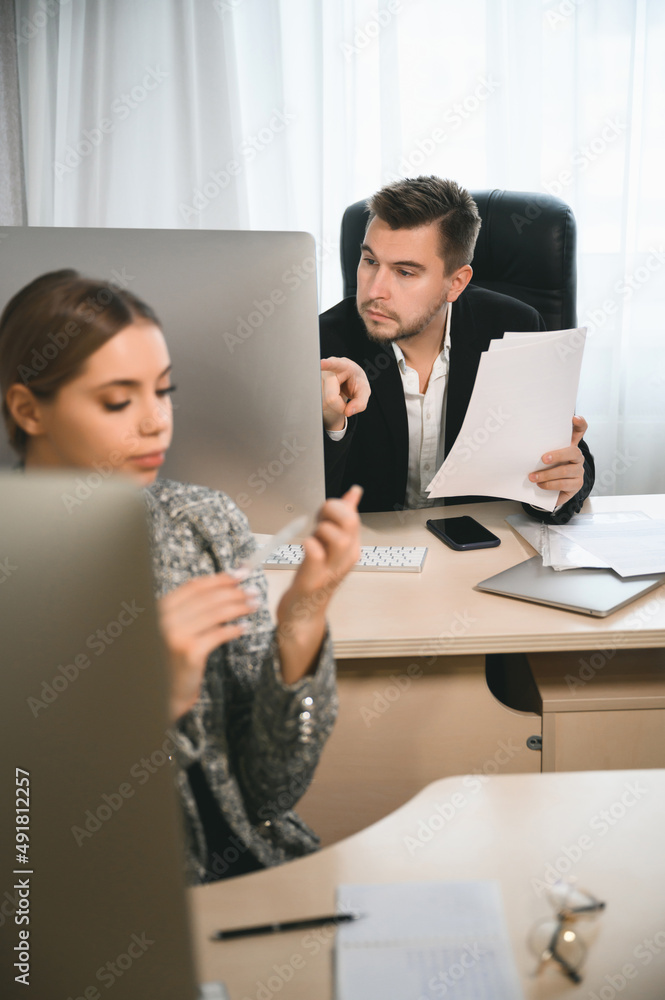 Young attractive woman and adult man are working in the office. Open space concept for teamwork Young attractive woman and adult man are working in the office. Open space concept for teamwork