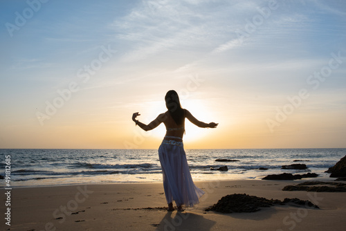 Fotografi Happy and calm woman poses on the beach wearing the typical belly dance costume
