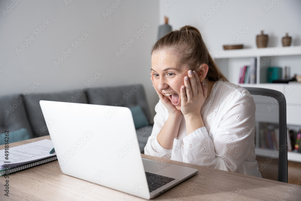 Surprised woman watching good results on laptop hands on face Surprised woman watching good results on laptop hands on face