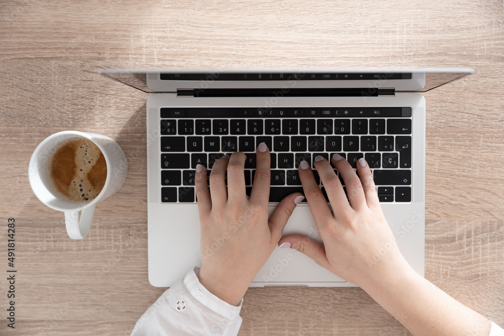 Fototapeta premium View from above of female hands typing on laptop. Copy writing and online business concept