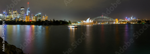 Sydney skyline panorama at night including light reflections in the harbour