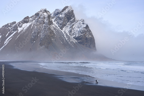 Stokksnes black sand beach and Mt Vestrahorn in winter. People on beach. Southeast Iceland. photo