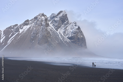 Stokksnes black sand beach and Mt Vestrahorn in winter. People on beach. Southeast Iceland. photo