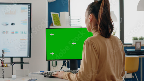 Close up of person using green screen on computer in business office. Woman working with mock up isolated template and blank background on desk. Adult with mock-up app on display