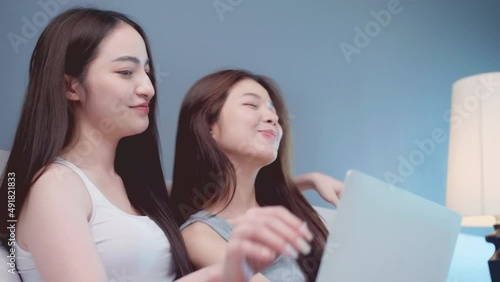Cozy young Asian beautiful woman  lesbian Lgbt couples sweetness together while using laptop at home. Asian young lesbian Lgbt relationship and travel concept for stock footage.