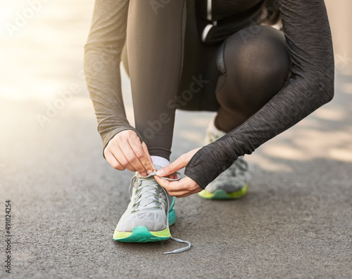 Its time to lace up. Shot of an unrecognizable young woman tying her laces before a morning run.