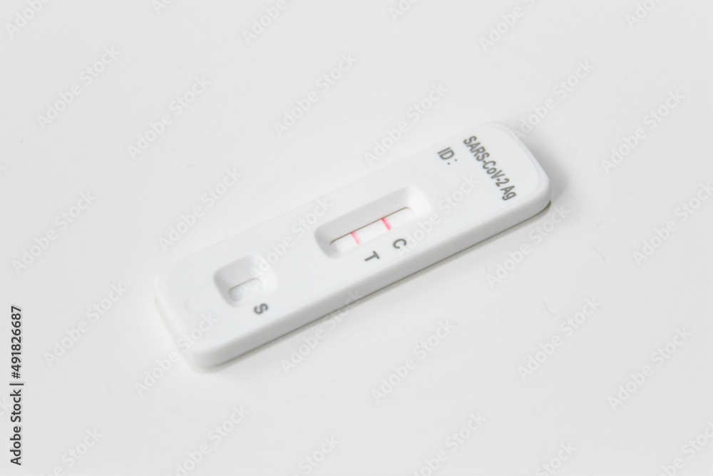One positive COVID-19 antigen, lateral flow, self tests. White test isolated on white background. Red line indicates positive result. One positive COVID-19 antigen, lateral flow, self tests. White test isolated on white background. Red line indicates positive result.