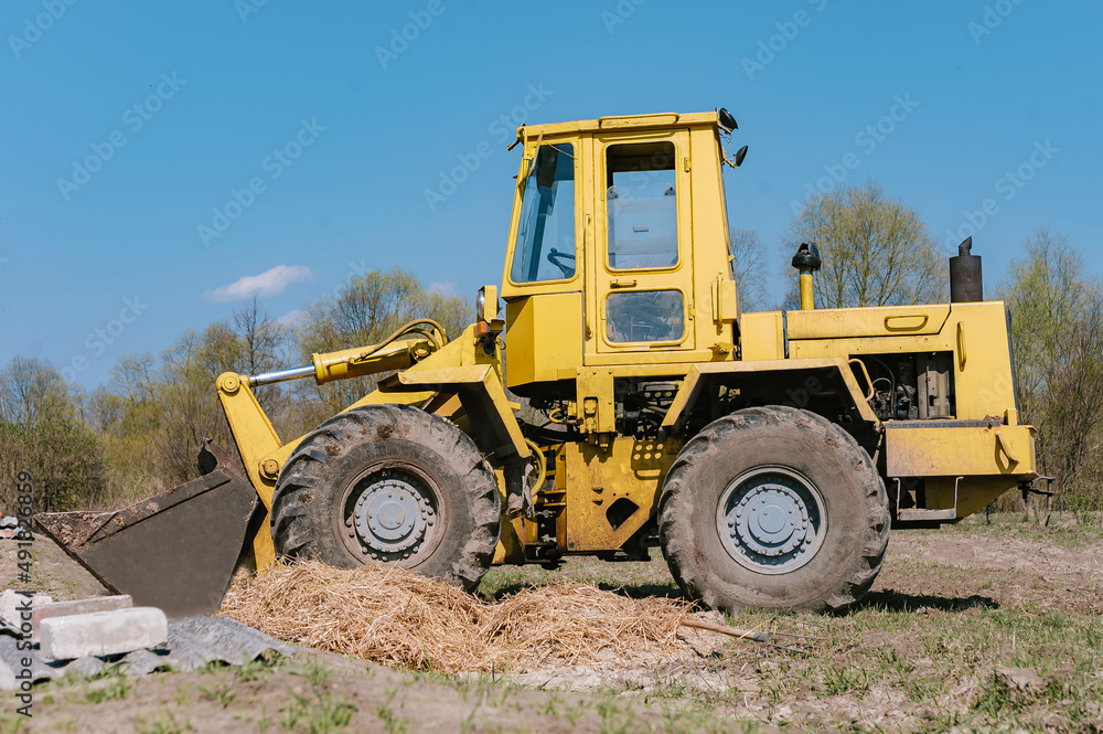 Yellow wheel loader excavator. Against the background of the field. Yellow wheel loader excavator. Against the background of the field.