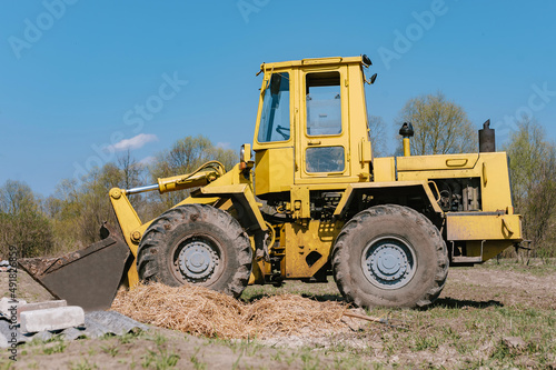 Yellow wheel loader excavator. Against the background of the field.