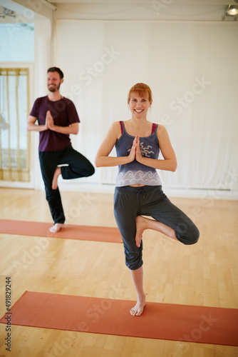 Enjoying their yoga session at the gym. Shot of two people doing yoga together in a studio.