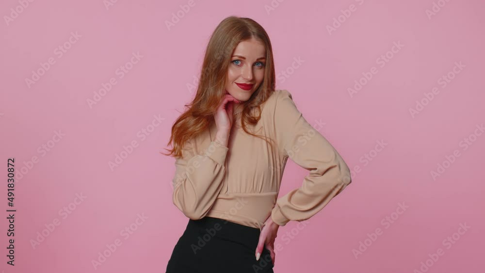 Smiling playful happy businesswoman girl in beige blouse blinking eye, looking at camera with toothy smile, winking, flirting, expressing optimism. Young pretty adult woman on pink studio background Smiling playful happy businesswoman girl in beige blouse blinking eye, looking at camera with toothy smile, winking, flirting, expressing optimism. Young pretty adult woman on pink studio background