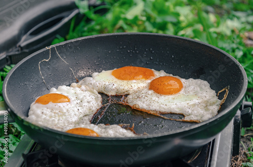 Scrambled eggs in a frying pan. Snack in nature. Appetizing food. Side view.