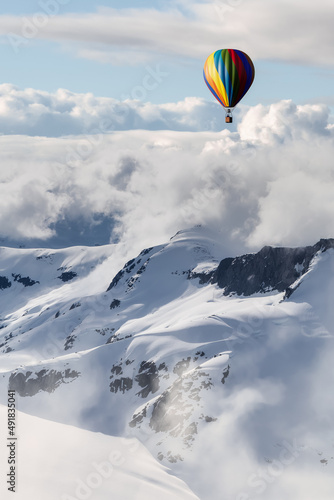 Dramatic Mountain Landscape covered in clouds and Hot Air Balloon Flying. 3d Rendering Adventure Dream Concept Artwork. Aerial Image from British Columbia, Canada.