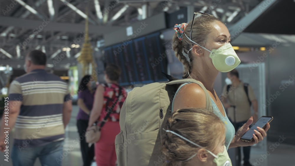 Woman and child baby tourist caucasian at airport with wearing protective medical mask. Family in quarantine isolation. Health safety virus protect coronavirus epidemic sars-cov-2 covid-19 2019-ncov.