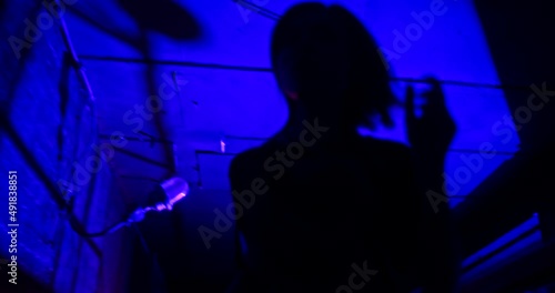 Slow motion low angle shot of scared victim running away from the pursuer. The witness of illegal fights is trying to hide in the dark corners of an underground club