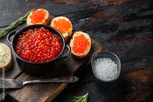 Canape toast with red caviar, on old dark  wooden table background  with copy space for text