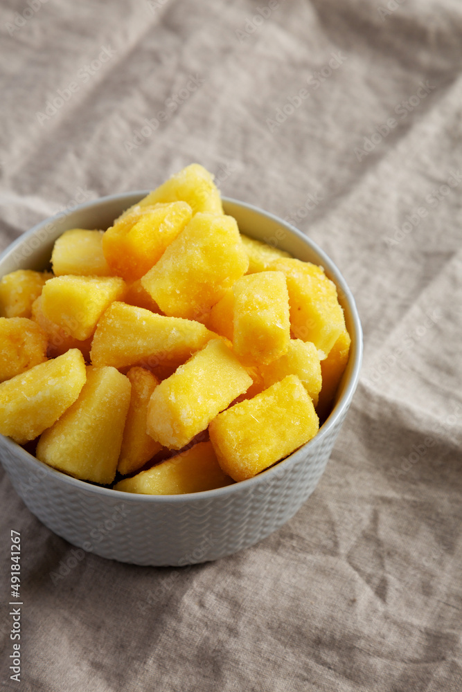 Organic Frozen Pineapple Slices in a Bowl, side view. Space for text. Organic Frozen Pineapple Slices in a Bowl, side view. Space for text.
