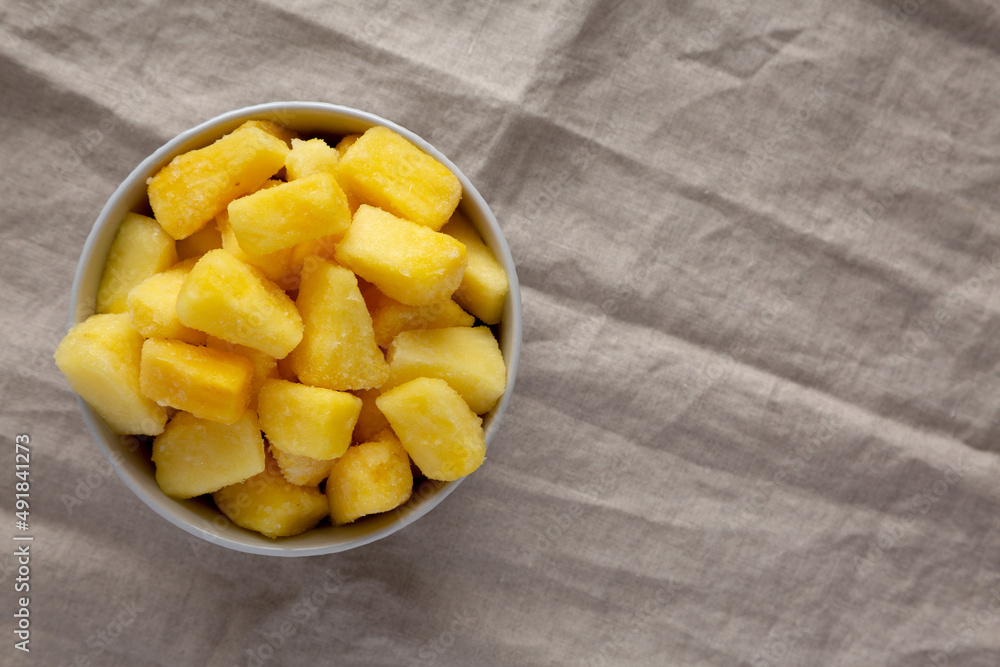 Organic Frozen Pineapple Slices in a Bowl, top view. Flat lay, overhead, from above. Copy space. Organic Frozen Pineapple Slices in a Bowl, top view. Flat lay, overhead, from above. Copy space.