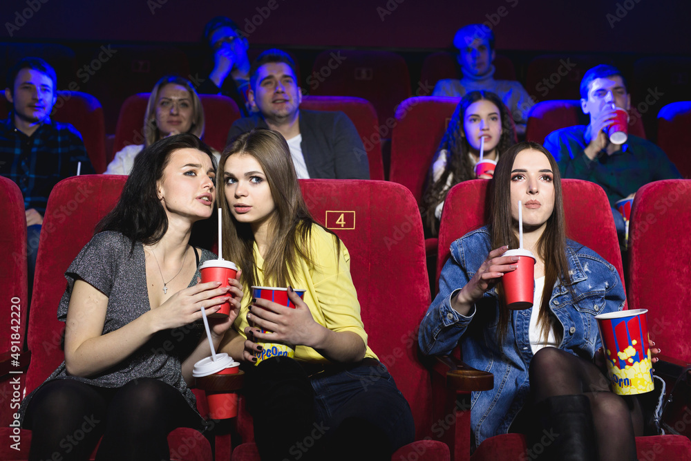 Girls watching a really boring movie at the cinema theater. Bad film