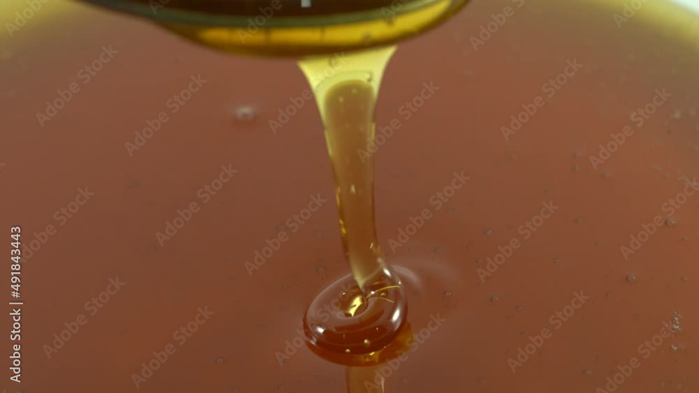 Honey poured from a white bowl is a healthy breakfast ingredient. Honey poured from a white bowl is a healthy breakfast ingredient.