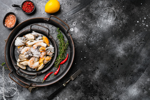 Seafood board with shrimp, squid mussel and octopus, on black dark stone table background, top view flat lay, with copy space for text