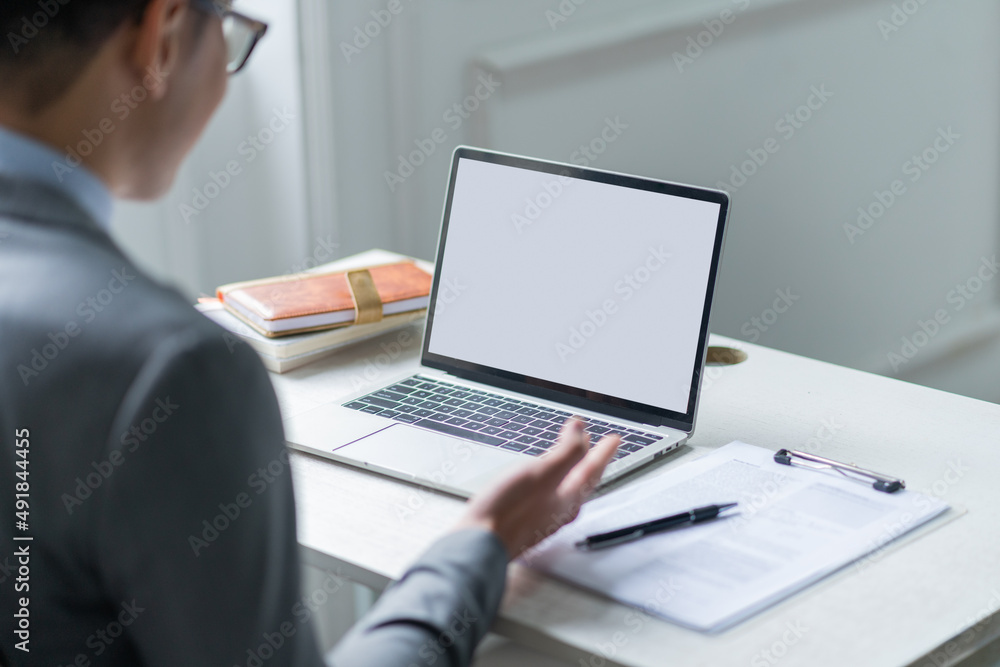 Young Asian businessman using laptop with blank display Young Asian businessman using laptop with blank display