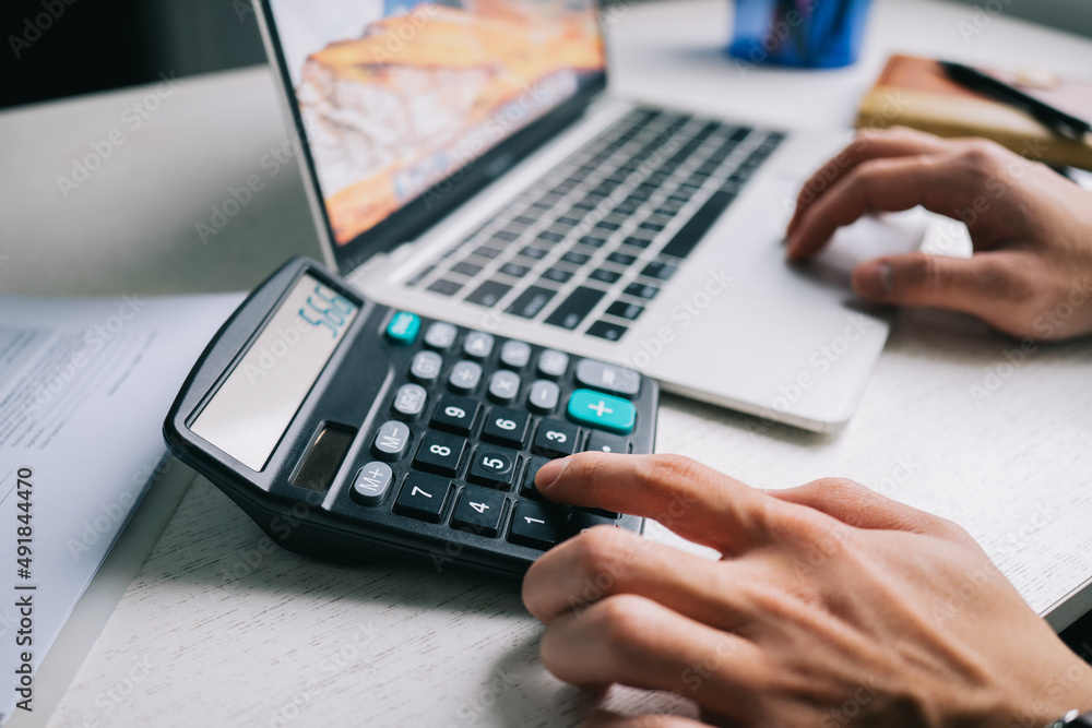 Asian Businessmen use a calculator to calculate tax and income Asian Businessmen use a calculator to calculate tax and income