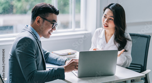 Canvastavla Two Asian businesspeople working at office