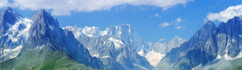 high mountains, rocky cliffs with trees, in the background you can see the French Alps with the snow-capped Mont Blanc, the concept of hiking, rock climbing, active lifestyle, beauty of nature