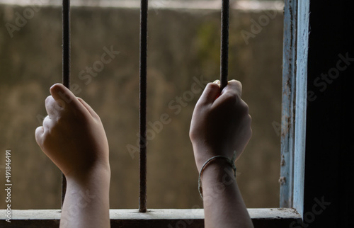 The child's hand was imprisoned in a cage. Indicates the deterioration of society, severe and depressing.