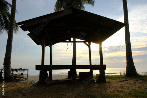 Tropical gazebo on an sandy island beach with coconut palm trees