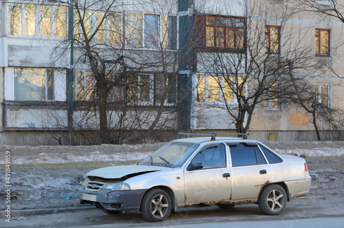 An old light broken rusty car is parked on the street, Iskrovsky Prospekt, St. Petersburg, Russia, March 2022 photo