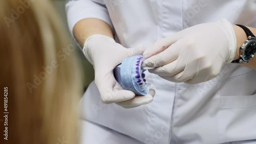 the dentist shows how the dental cap works on the jaw model