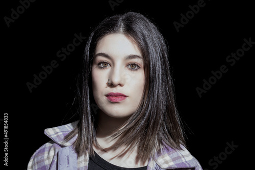 portrait of brunette woman looking at camera on black background