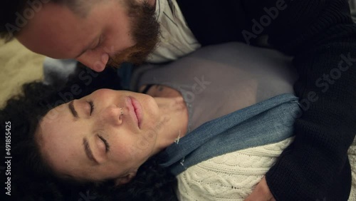 Sleepy couple kissing cheek on sandy beach sea. Lovers cuddling together outside