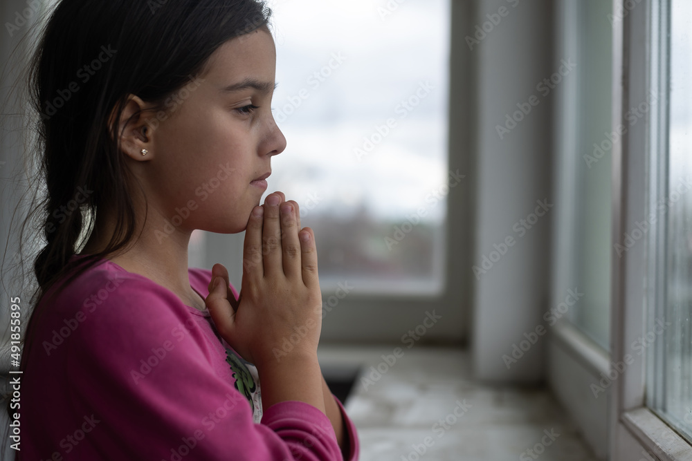 Little girl praying on the white table in the morning. Little girl hand praying, Hands folded in prayer concept for faith, spirituality and religion. Little girl praying on the white table in the morning. Little girl hand praying, Hands folded in prayer concept for faith, spirituality and religion.