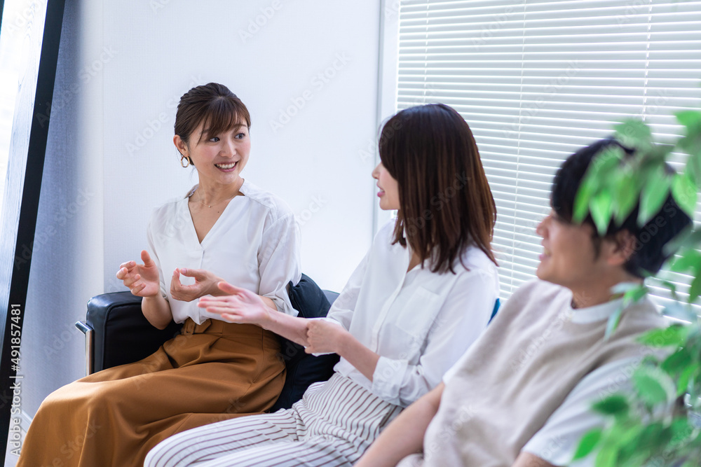 Obraz premium 職場で楽しく話す若手会社員
