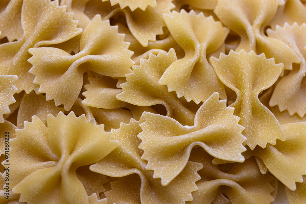 Pasta bows from durum wheat. Food background close up. Uncooked Italian pasta. Pasta bows from durum wheat. Food background close up. Uncooked Italian pasta.