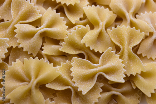 Pasta bows from durum wheat. Food background close up. Uncooked Italian pasta.