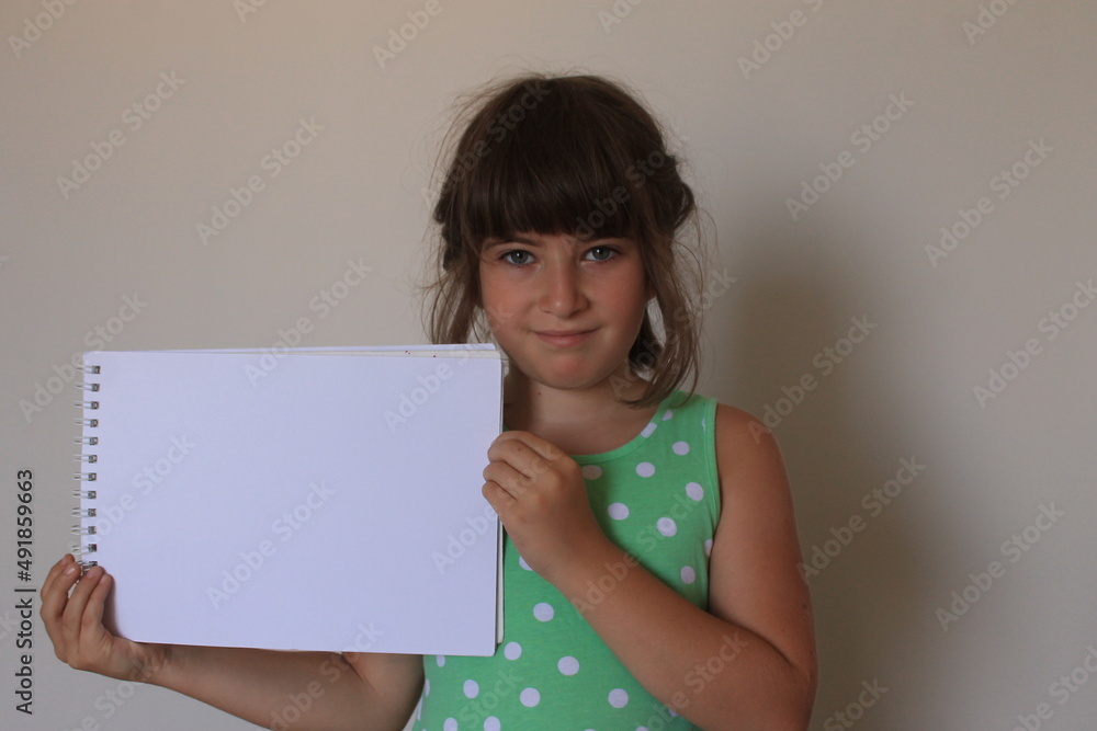 A 10 year old girl holding a blank paper A 10 year old girl holding a blank paper