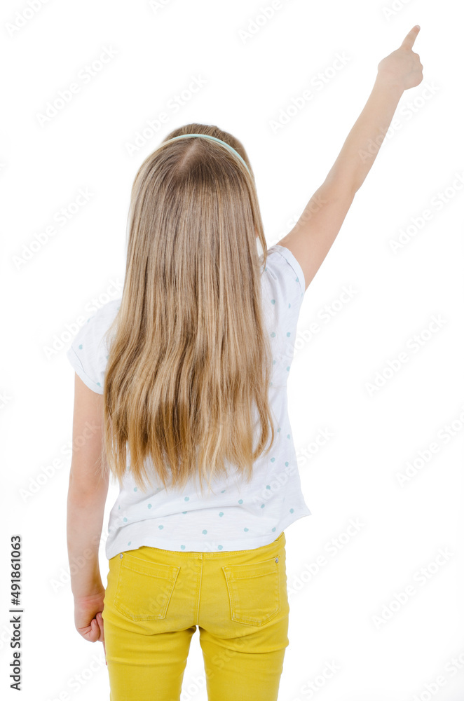 Back view of little girl pointing up at wall. Adorable girl standing ...