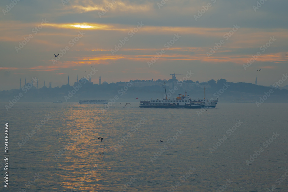 fisherman boats fishes on Bosphorus Istanbul on a Foggy sunrise. Rainy clouds and dark weather. Historical Istanbul view